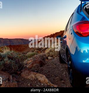 Voiture de tourisme en tout-terrain avec coucher de soleil paysage. Vue rapprochée de la voiture bleue. Banque D'Images