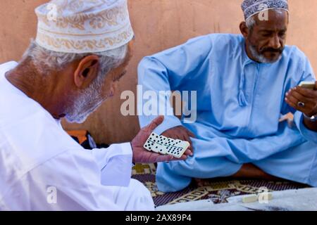 Hommes omanais jouant dans la rue, Oman. Banque D'Images