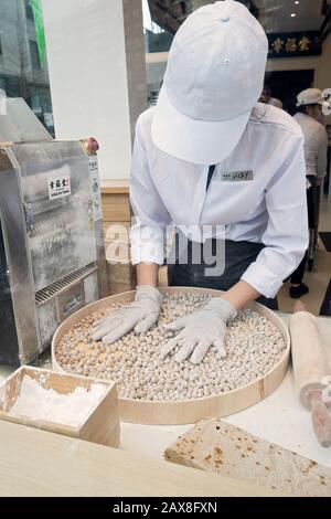 Un jeune américain asiatique fait des boules de tapioca pour boire du boba dans la fenêtre de Xing Fu Tang, un magasin taïwanais sur la rue principale à Flushing, Queens, Chinatown Banque D'Images