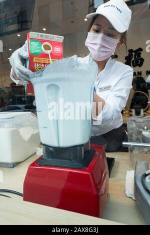 Un jeune américain asiatique prépare des boissons boba dans la fenêtre de Xing Fu Tang, un magasin taïwanais sur Main St. à Flushing, Queens, quartier chinois de New York. Banque D'Images