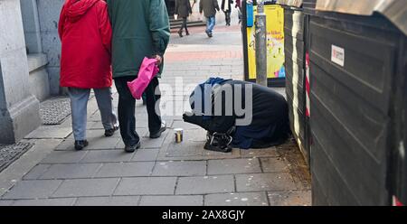 Femme mendiant à North Street Brighton tout en apparaissant pour prier East Sussex UK Photographie prise par Simon Dack Banque D'Images