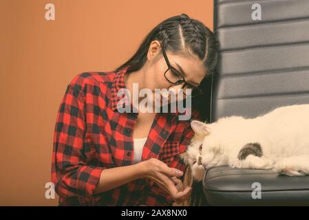 Une jeune femme asiatique portant une chemise à damier rouge sur fond brun Banque D'Images