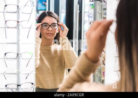 gros plan portrait d'une belle femme qui choisit des lunettes. jeune avec mauvaise vue Banque D'Images