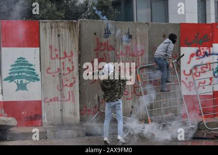 Centre-Ville De Beyrouth, Liban. 11 février 2020. Un manifestant jette un canister de gaz de terre abattu par la police sur une barrière en béton. Les gens se sont réunis pour protester contre les obstacles qui les empêchent d'atteindre le parlement le jour d'un vote de confiance dans le nouveau cabinet proposé par le PM provisoire Hassan Diab. Crédit: Elizabeth Fitt/Alay Live News Banque D'Images