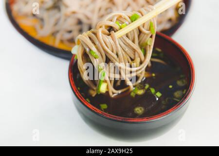 Les nouilles froides de style japonais ou les ramen de zaru restent dans des baguettes avec un éclairage intérieur. Banque D'Images