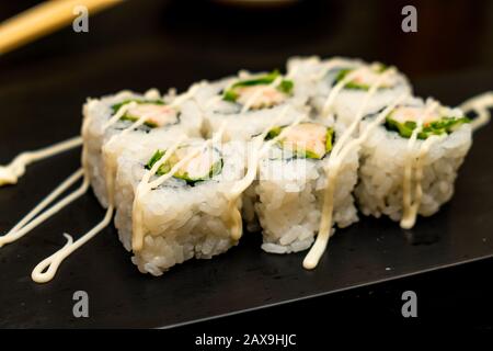 Véritable sushi japonais dans un restaurant à Tokyo. Jeu de sushi sur une plaque noire en pierre Banque D'Images