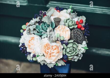 Fleurs faites à la main en argile polymère japonaise. Ils ressemblent à un véritable bouquet de mariage. Sur le fond d'une porte en bois vert Banque D'Images