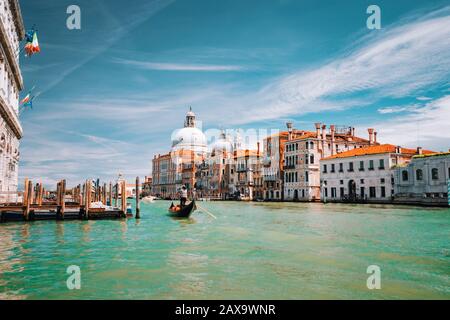 Venise, Italie. Excursion en gondole touristique sur le Grand Canal. Basilique Santa Maria della Salute contre le ciel bleu et les nuages blancs Banque D'Images