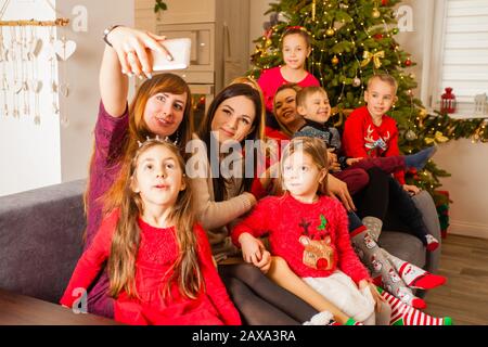 Les mères et leurs enfants font du selfie sur le canapé Banque D'Images