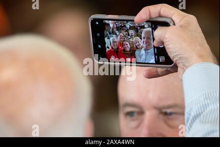 L'ancien vice-président américain Joe Biden prend des selfies avec les électeurs de Hampton, N.H., aux États-Unis, pendant le primaire présidentiel du New Hampshire, 9 février 2020. Banque D'Images
