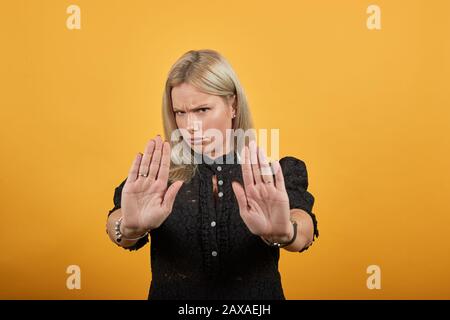 fille en robe noire une femme irritée montre des mains qui symbolisent l'arrêt Banque D'Images