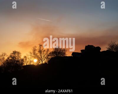 Les formations rocheuses de Gristan ont été silhouettées contre un ciel coucher de soleil à Brimham Moor Nidhair AONB North Yorkshire England Banque D'Images