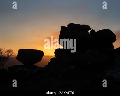 Les formations rocheuses de Gristan ont été silhouettées contre un ciel coucher de soleil à Brimham Moor Nidhair AONB North Yorkshire England Banque D'Images