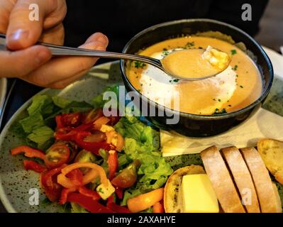 homme mangeant une soupe de crème de homard avec salade et pain au beurre au restaurant Banque D'Images