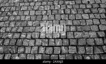 Granite pavé pavé de pierre cubique gros plan de la texture de l'arrière-plan. Fond d'écran ou texture de la chaussée. Photographie noir et blanc Banque D'Images