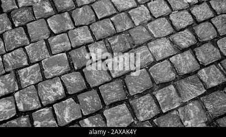 Granite pavé pavé de pierre cubique gros plan de la texture de l'arrière-plan. Fond d'écran ou texture de la chaussée. Photographie noir et blanc Banque D'Images