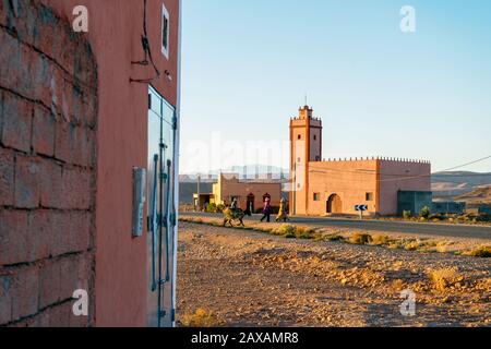 Petit village avec des gens près de la mosquée au Maroc Banque D'Images