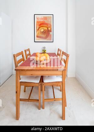 Table et chaises en bois confortables, cadre photo dans une cuisine moderne spacieuse. Banque D'Images