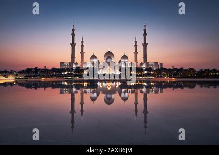 Abu Dhabi au coucher du soleil. Vue extérieure sur la mosquée éclairée. Emirats Arabes Unis. Banque D'Images