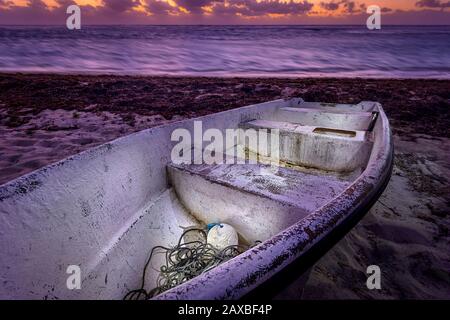 Vieux bateau sur la plage au lever du soleil, île Grand Cayman Banque D'Images