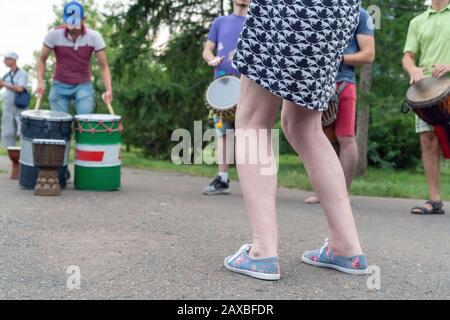 Jambes d'une femme dansant dans la rue à proximité. Jouer sur Tom-Toms et batterie. Divertissement et fête dans le parc Banque D'Images