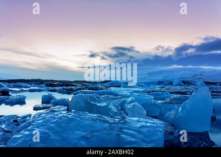 Froid islande glacier jokulsarlon dans les icebergs du soir flottant sur l'eau froide paisible après le coucher du soleil Banque D'Images