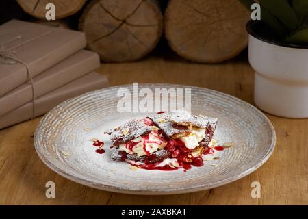 crème de dessert française de pâte feuilletée, crème anglaise et crème glacée sur une assiette et sur une table en bois, gros plan. Banque D'Images