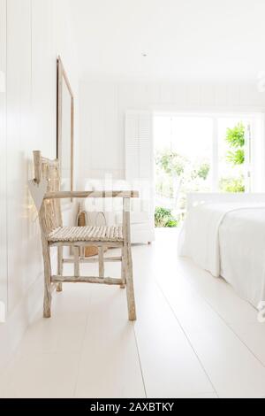Fauteuil en bois simple dans la chambre de la maison de plage blanche Banque D'Images