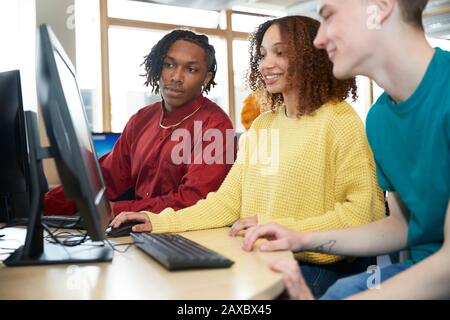 College students using computer in library Banque D'Images