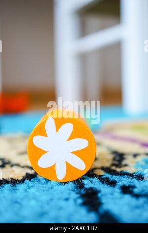 Jouet circulaire orange avec une fleur blanche pour les enfants sur une surface multicolore Banque D'Images