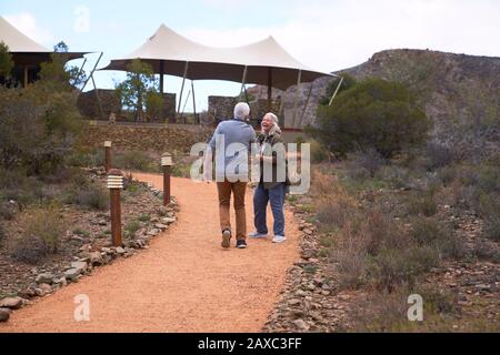 Un couple senior heureux qui marche sur le sentier à l'extérieur du safari Lodge Banque D'Images