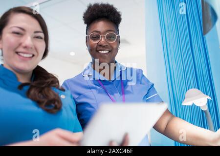 Portrait confiante médecin et infirmière féminine utilisant une tablette numérique dans la salle d'hôpital Banque D'Images