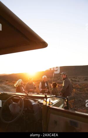 Safari groupe buvant du champagne au coucher du soleil Afrique du Sud Banque D'Images