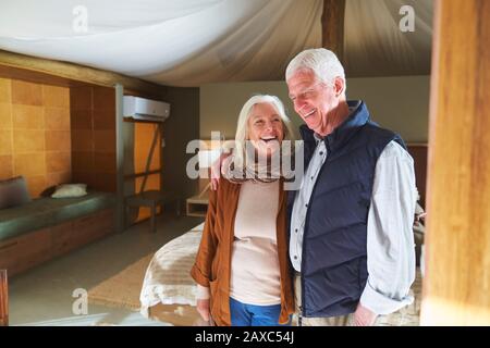 Un couple senior heureux riant dans la chambre d'hôtel Banque D'Images