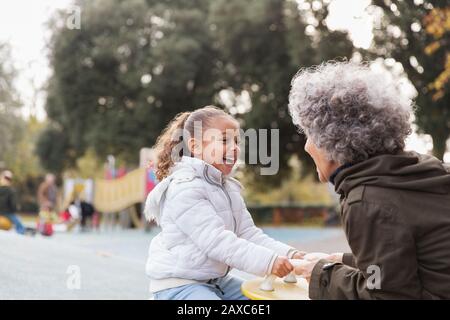 Grand-mère et petite-fille jouant à l'aire de jeux Banque D'Images