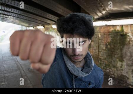 Portrait dur jeune homme poinçonner dans le tunnel urbain Banque D'Images