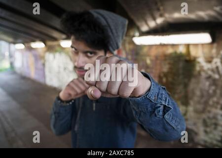 Portrait dur jeune homme poinçonner dans le tunnel urbain Banque D'Images