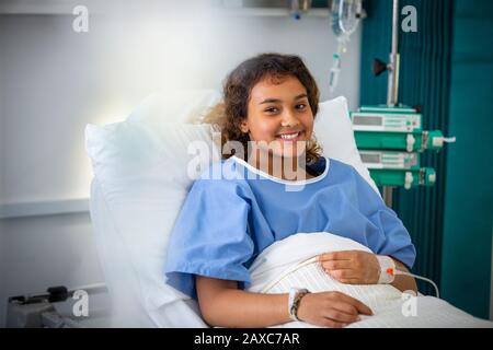 Portrait souriant fille patient dans le lit d'hôpital Banque D'Images
