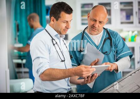 Médecins masculins utilisant une tablette numérique à l'hôpital Banque D'Images
