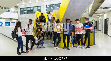 Les étudiants juniors penchant dans les escaliers Banque D'Images