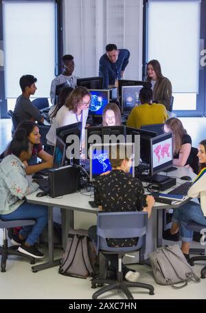 Jeunes étudiants et enseignants utilisant des ordinateurs en laboratoire informatique Banque D'Images