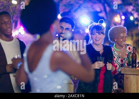 Joyeux amis à boire et à chanter karaoké à la fête du jardin Banque D'Images