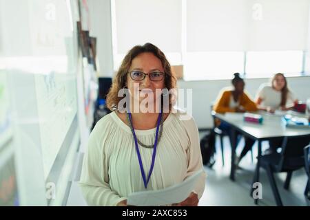 Portrait confiant professeur de lycée féminin à l'écran de projection dans la salle de classe Banque D'Images