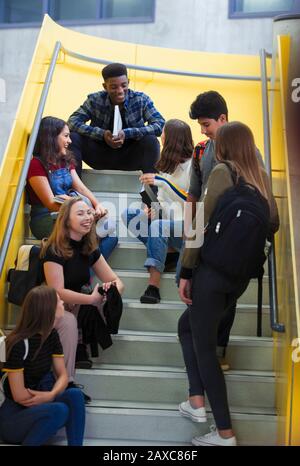 Les étudiants juniors penchant sur les escaliers Banque D'Images