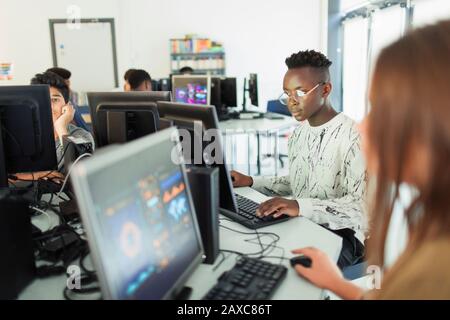 L'accent junior high boy student using computer in computer lab Banque D'Images