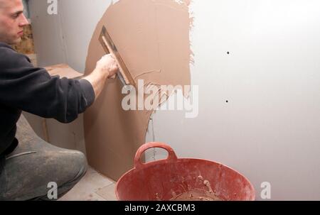 mur intérieur de plâtrage d'homme Banque D'Images