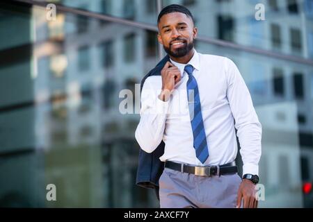 Portrait d'homme d'affaires afro-américain moderne dans la ville urbaine, à pied au travail dans le quartier financier Banque D'Images
