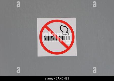 Panneau non fumeur sur le mur gris, concept de soins de santé, arrêt du tabac. Fumer la cigarette dans un cercle rouge barré. Stocker la photo avec un espace vide pour le texte. Banque D'Images