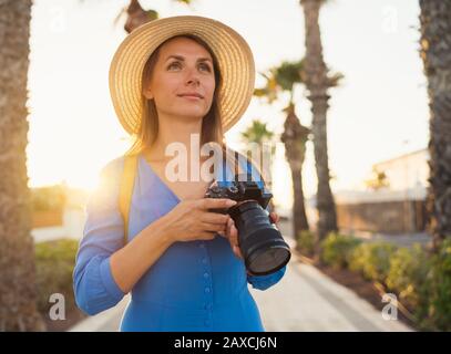 Heureuse photographe touristique femme prenant des photos avec appareil photo dans un beau paysage tropical au coucher du soleil Banque D'Images