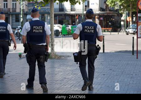 Bruxelles, Belgique - 03 juillet 2019: Trois policiers en gilet à protection contre les balles patrouillent dans la rue de la capitale. Banque D'Images